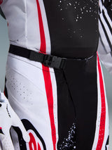 Alpinestars 2026 Techstar Nomur Pants, Motocross Pants, Black White and Red, close-up of the SX2 magnetic buckle waist closure and laser-perforated technical fabric with splatter print details.