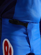Alpinestars 2026 Fluid Grid Pants, Motocross Pants, Blue and Red, close-up view of the black ratchet waist closure system, durable blue polyfabric with red and white logo accent, engineered for off-road performance