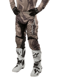 Alpinestars 2024 Racer Tactical Pants, Motocross Pants, Military Green Camo Brown, worn with matching camouflage jersey, black gloves, and white boots with star logos, featuring black stretch panels and ergonomic design, off-road gear setup on white background