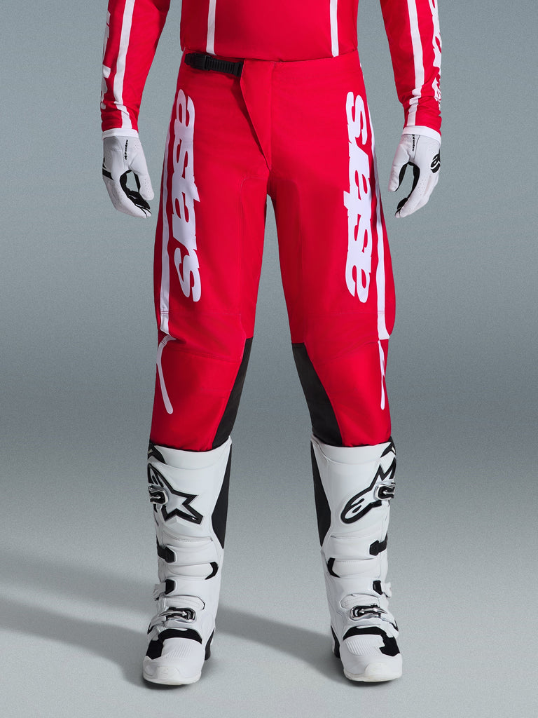 Alpinestars 2026 Fluid Apex Pants, Motocross Pants, Red and White, featuring large white Astars logos on the thighs and black inner knee panels, worn with matching white and black boots and gloves for a complete off-road racing look.