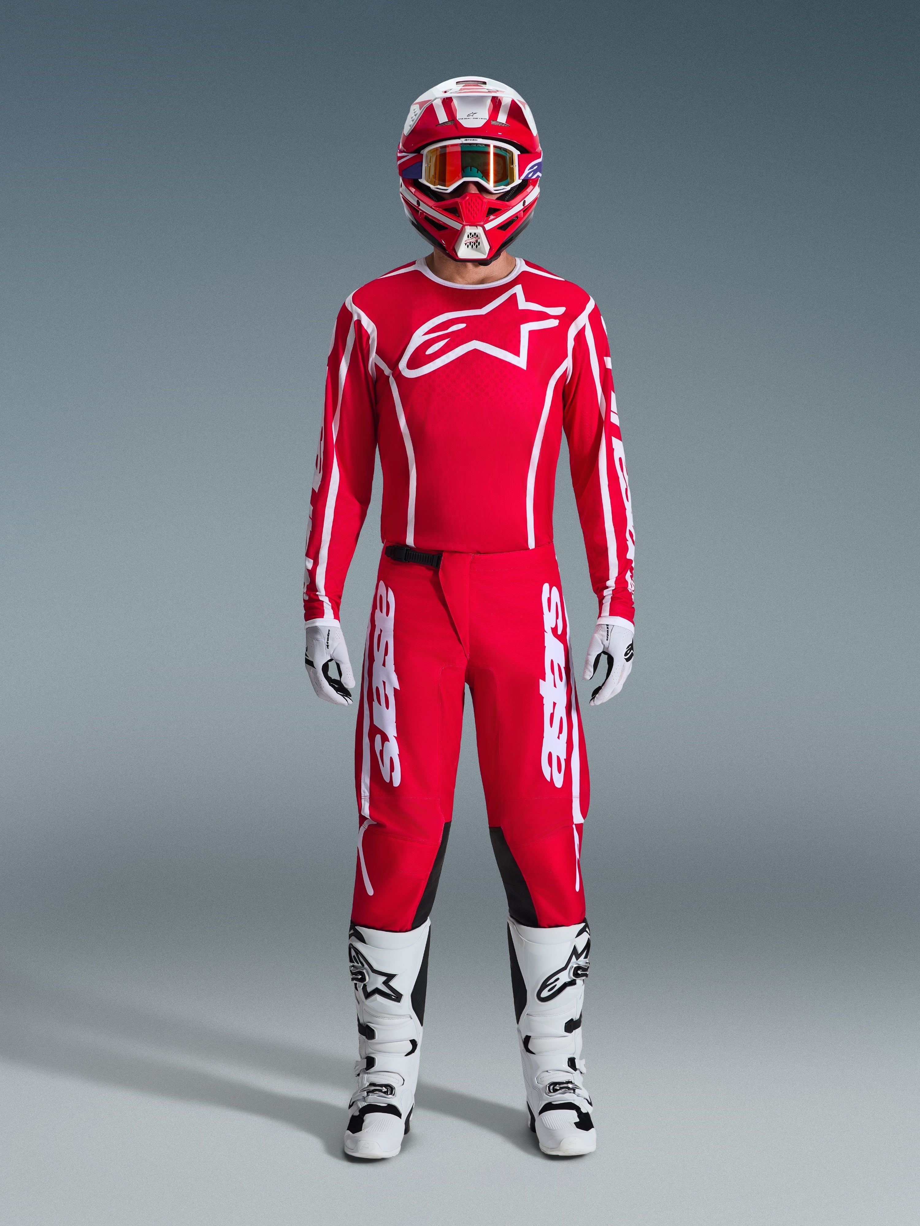 Alpinestars 2026 Fluid Apex Pants, Motocross Pants, Red and White, worn as a full racing gear set with a matching red jersey, white boots, and red and white helmet, featuring bold branding and black panels for off-road performance.