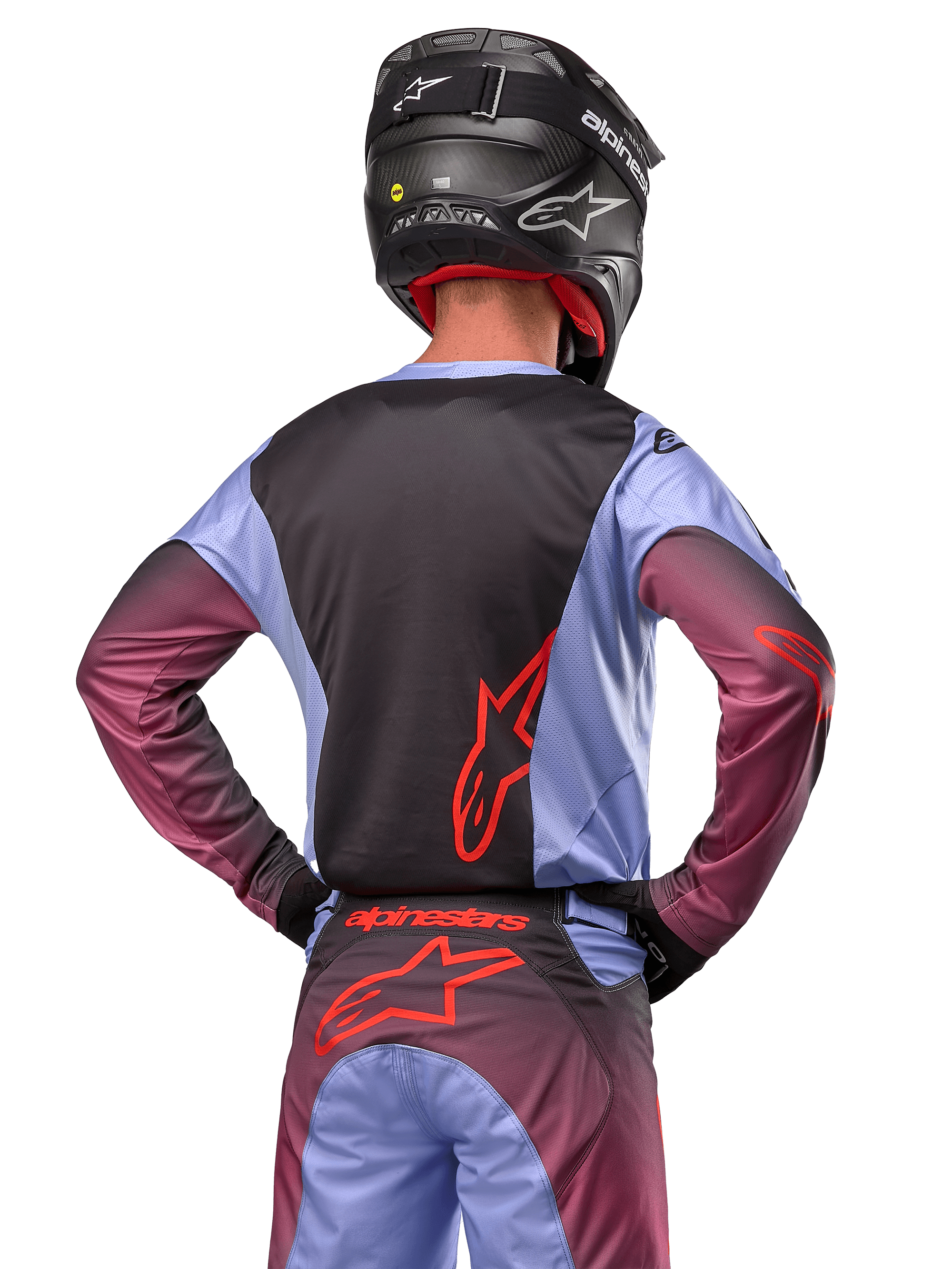 Motocross rider from the back wearing Alpinestars 2024 Racer Hoen gear, Lavan Purple and Black jersey with red logo, matching pants with red accents, black helmet, coordinated outfit for off-road racing