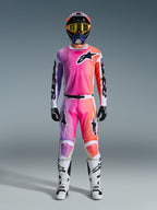 Motocross rider wearing the 2026 Racer Air Portl Jersey and matching pants, featuring a pink, purple, and orange gradient with black Alpinestars logos, white racing boots, black gloves, and a multicolor helmet, professional off-road racing gear.