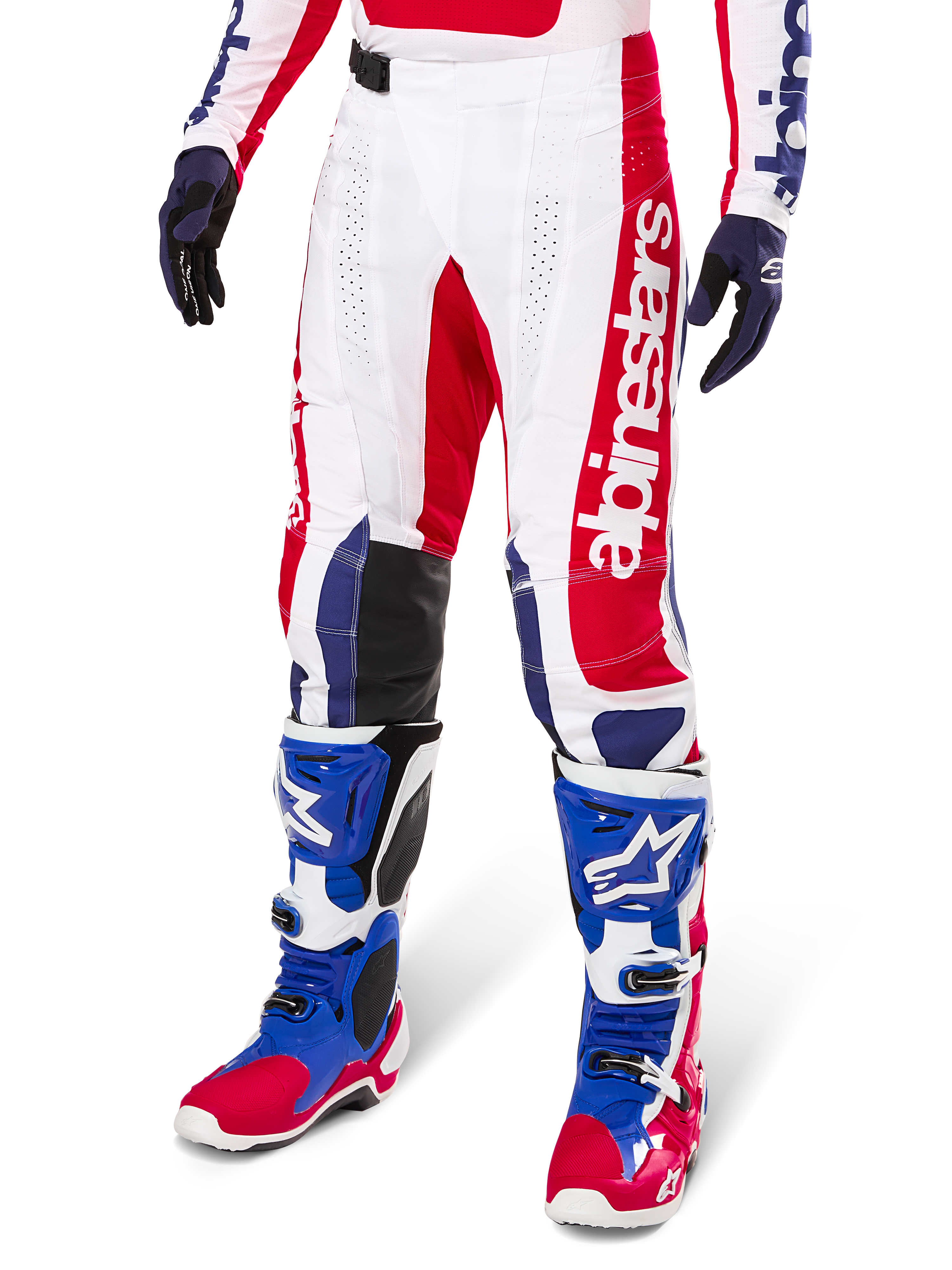 Alpinestars Limited Edition Techstar Fortitude Pants, Motocross Pants, Bright Red White and Blue, worn with matching off-road boots and gloves, featuring vertical branding on the leg, breathable perforated panels, and black reinforced knee sections, athletic race fit design