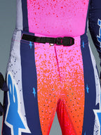 Alpinestars Limited Edition Supertech Records Pants, Motocross Pants, Multicolor pink and orange with navy blue side panels, close-up view of the waist featuring a black SX1 auto-locking magnetic buckle, rip-stop fabric with splatter graphics and laser-cut perforations.
