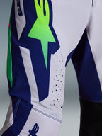Alpinestars 2026 Supertech Vista Pants, Motocross Pants, Light Gray Yellow Fluo and Blue, close-up detail of the thigh and knee area featuring a bold neon green star logo on a blue panel, laser-cut perforations for ventilation, and black inner knee panels.
