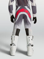 Alpinestars Youth Supertech Swan Motocross Pants in Gray and Red Fluo, rear view showing athletic fit and reinforced seat.