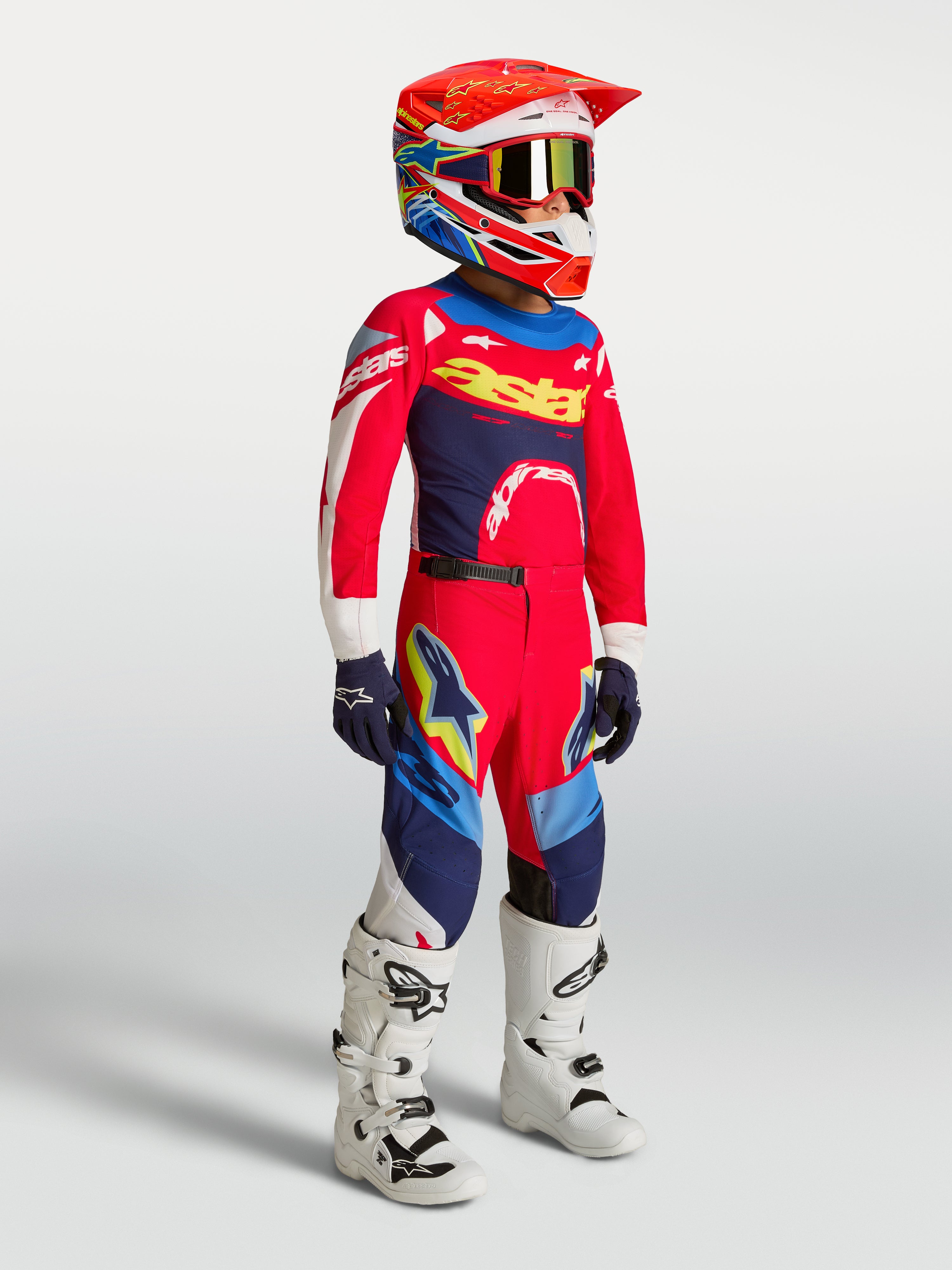 Alpinestars Youth Supertech Dyna Pants, Red and Navy Blue Motocross Gear, on-model with matching jersey, helmet, and boots.