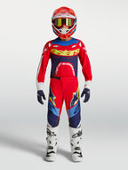 Alpinestars Youth Supertech Dyna Pants, Fire Red and Navy Blue Motocross Gear Set with White Boots and helmet.