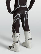 Alpinestars Youth Fluid Apex V2 Pants, Motocross Racing Gear, Youth, Black and Silver, Rear view with white boots.