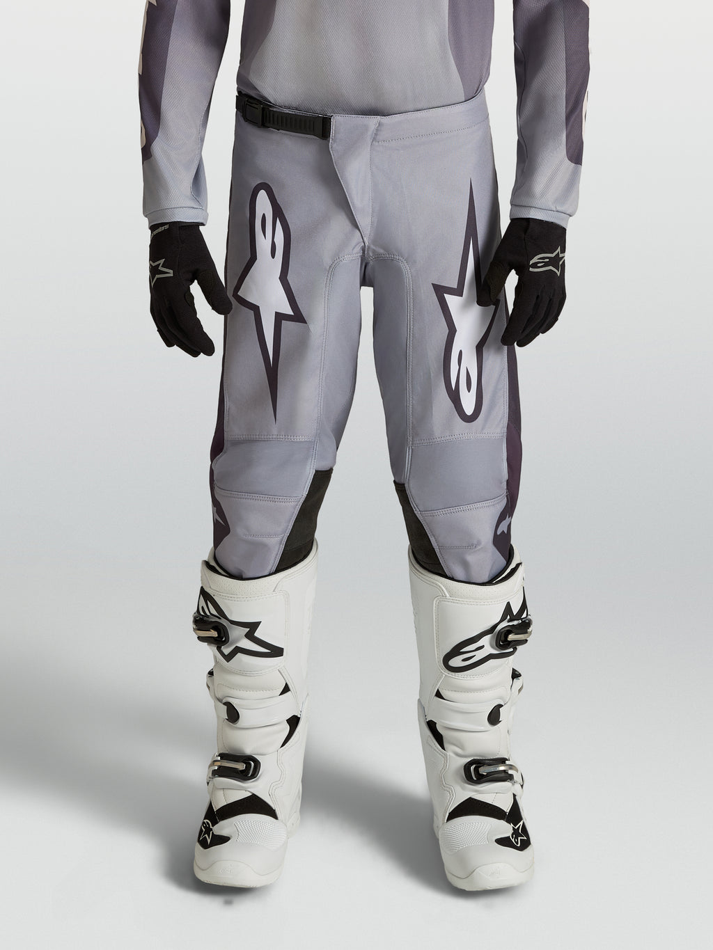 Alpinestars Youth Fluid Amber Pants, durable grey and black motocross pants for young riders in an off-road setting.