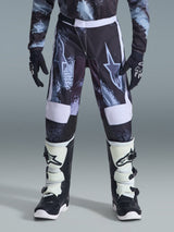 Alpinestars 2026 Youth Fluid Lahnd Pants, Youth Motocross Pants, Iron Camo with white accents, worn with black and white off-road boots and gloves, durable design for young riders.