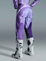 Alpinestars 2026 Woman Stella Fluid Apex Pants, Motocross Pants, Violet and White, featuring a large white Alpinestars logo on the back, worn with matching jersey and white and black boots, back view of rider in off-road racing gear