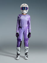 Alpinestars 2026 Stella Fluid Apex Pants, Motocross Pants, Violet and White, worn with matching long-sleeve jersey, white helmet with purple goggles, black and purple gloves, and white and black boots, complete coordinated racing outfit for women