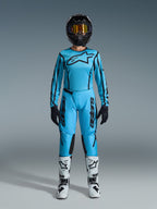 Alpinestars 2026 Stella Fluid Apex Gear Set, Women's Motocross Jersey and Pants, Blue and Black, featuring large star logo on chest, worn with black helmet, tinted goggles, and white boots with black accents, complete off-road racing outfit