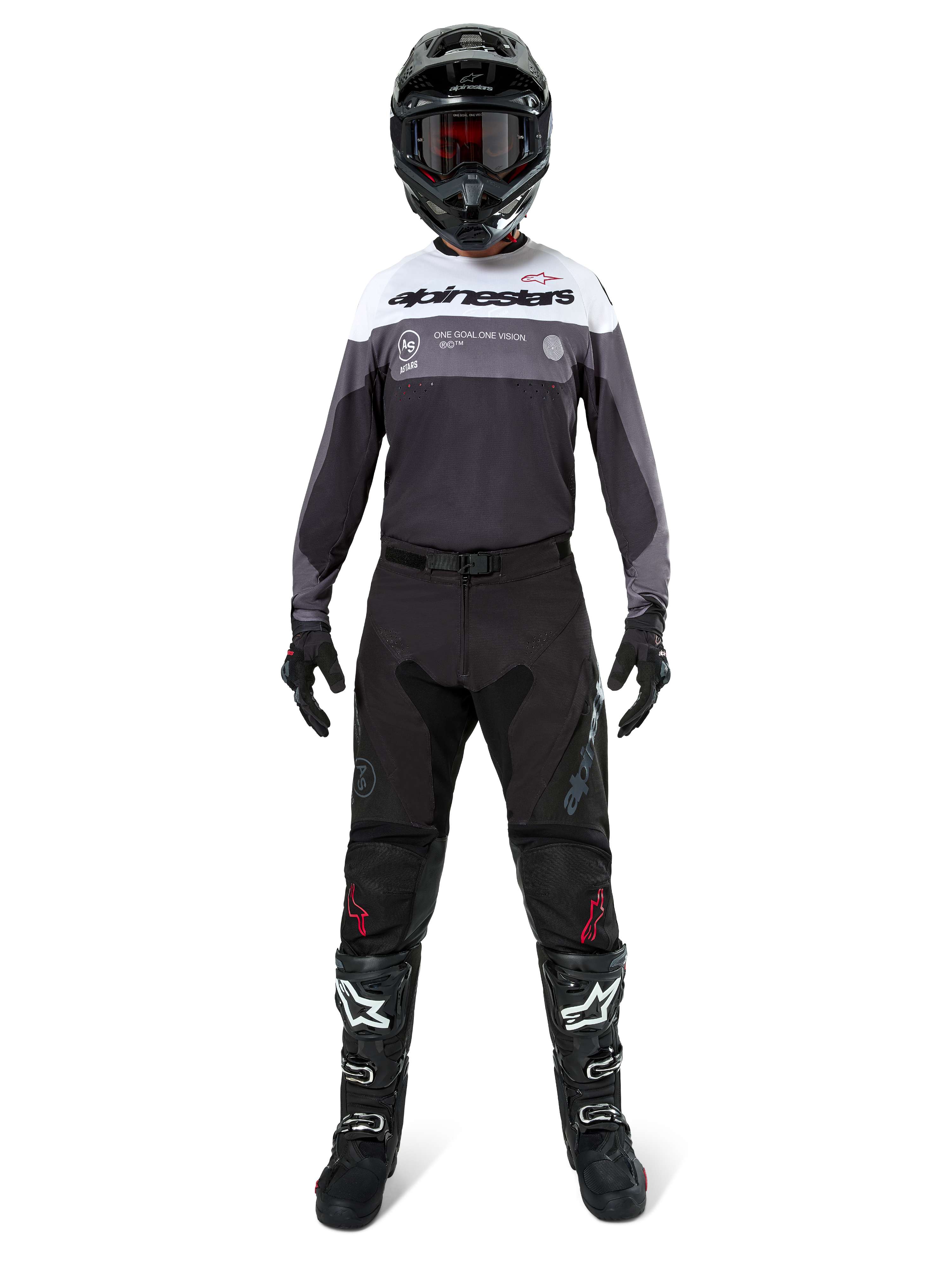 Motocross rider wearing complete racing gear, Pro-Dura Jersey in Black Magnet White with white upper chest and grey accents, paired with black pants, black helmet with dark goggles, white and black boots, and black gloves, coordinated outfit for enduro and off-road racing