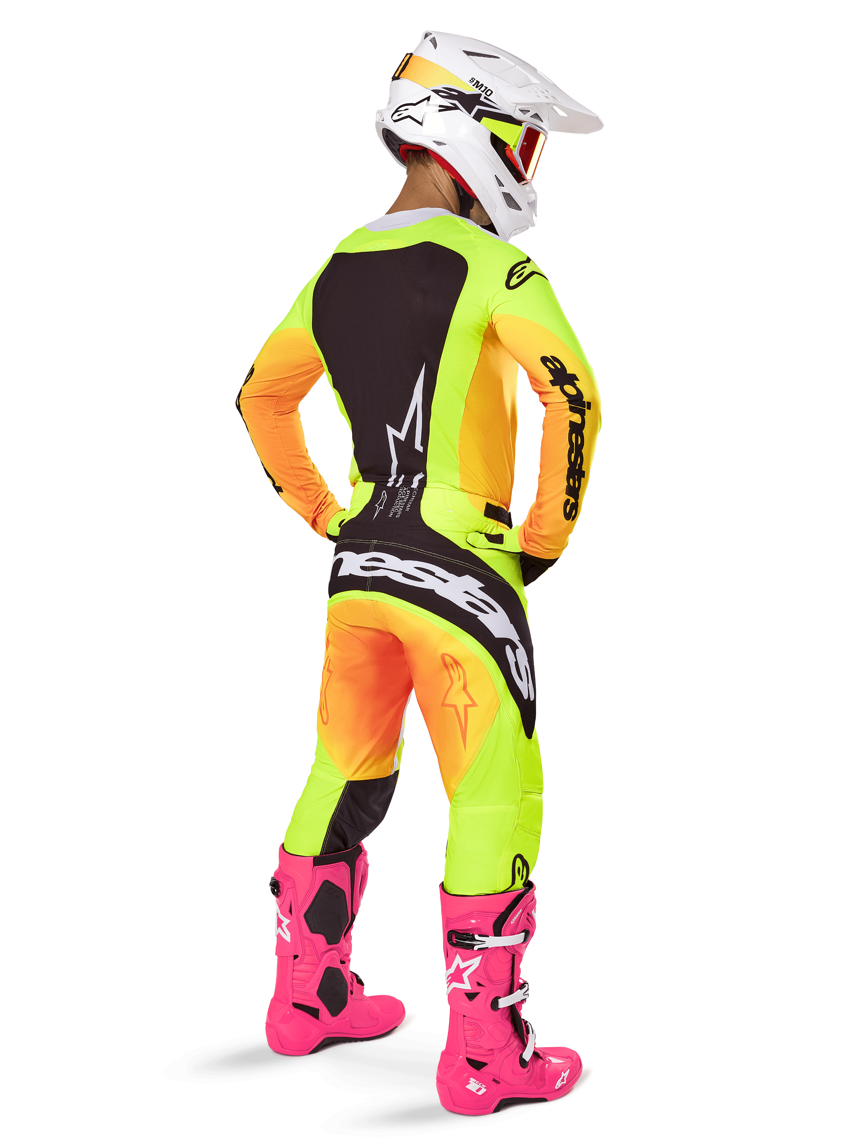 Motocross rider from the back wearing Alpinestars 2025 Techstar Melt Jersey, vibrant yellow and orange gradient with black sections, matching motocross pants, bright pink boots, and white helmet, athletic fit for off-road competition.