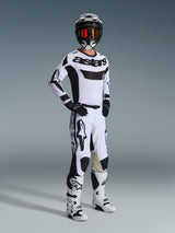Motocross rider wearing complete racing gear, Alpinestars 2026 Racer Riway Jersey in White and Black, matching white and black motocross pants, black helmet with mirrored goggles, white and black boots, and black gloves, coordinated outfit for off-road racing