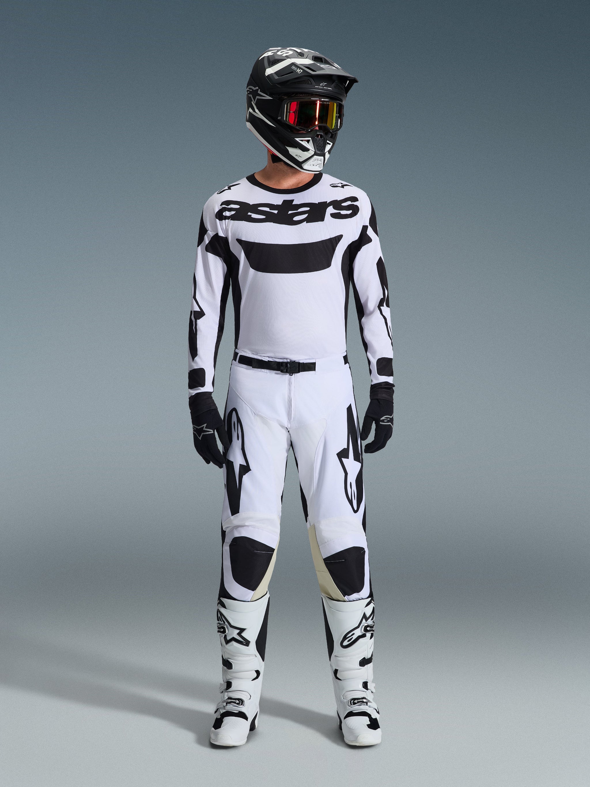Alpinestars 2026 Racer Riway Jersey, Motocross Jersey, White and Black, worn as a complete racing kit with matching pants, black helmet with red goggles, black gloves, and white boots, featuring bold black 'astars' branding and star logos.