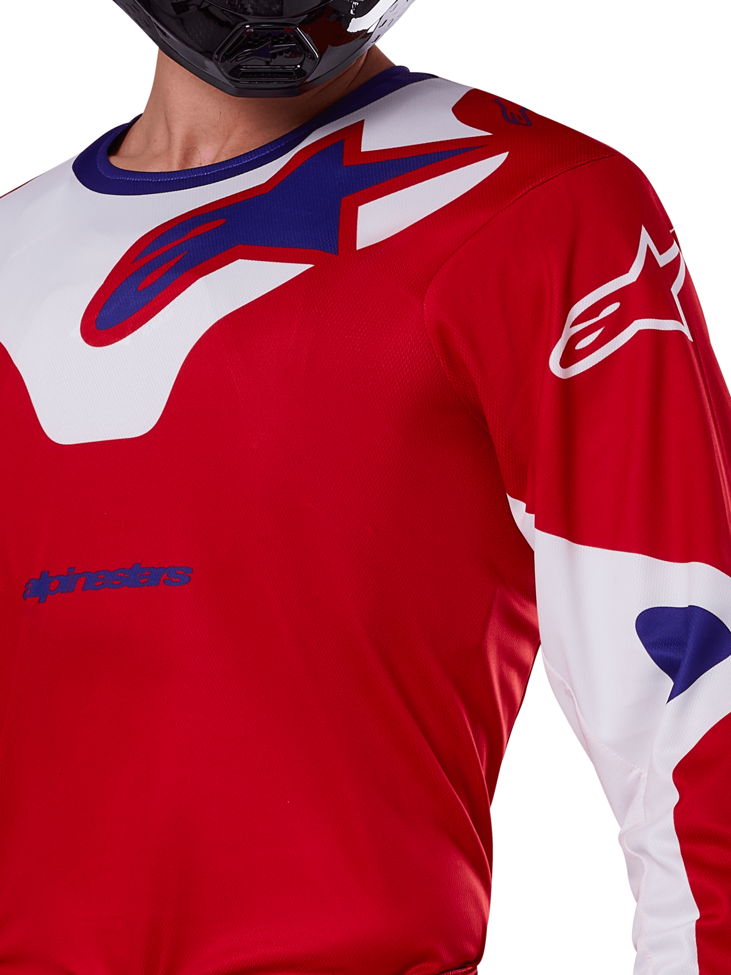 Alpinestars 2025 Racer Veil Jersey, Motocross Jersey, Bright Red and White, close-up view of the upper torso and chest, blue Alpinestars logo on a white collar panel, red sleeves with white accents, worn with a black helmet, technical off-road riding apparel