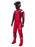 Motocross rider wearing Alpinestars 2025 Fluid Haul Gear Set, Bright Red with Black and White accents, complete outfit including jersey, pants, helmet, boots, and gloves, designed for off-road performance and protection