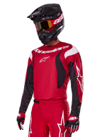 Motocross rider wearing Alpinestars 2025 Fluid Haul Gear Set in Red, featuring a red jersey with white and black accents, matching red pants with white graphics, black helmet with white branding, red and yellow goggles, and red and black gloves, coordinated motocross racing outfit