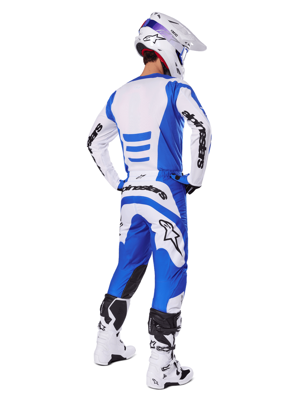 Motocross rider from the back wearing the Alpinestars 2025 Fluid Haul Gear Set, Blue and White jersey with matching pants, white helmet with blue accents, and white and black racing boots, coordinated off-road racing outfit