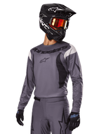 Alpinestars 2025 Fluid Haul Gear Set, Gray Motocross Jersey and Pants, featuring black and white accents, worn with a black helmet, red goggles, and black gloves, athletic sport fit for off-road riding