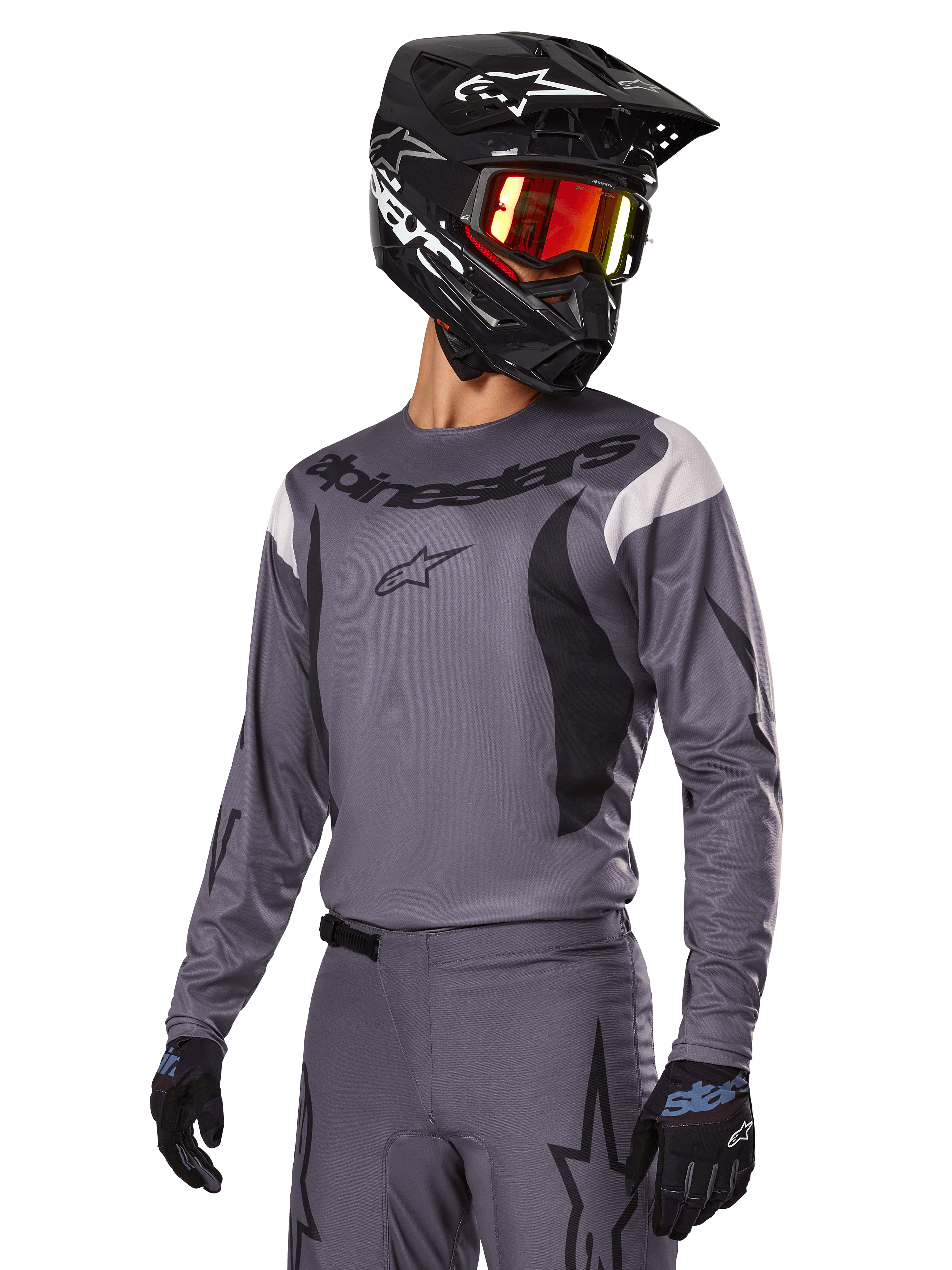 Alpinestars 2025 Fluid Haul Gear Set, Gray Motocross Jersey and Pants, featuring black and white accents, worn with a black helmet, red goggles, and black gloves, athletic sport fit for off-road riding