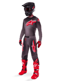 Alpinestars 2025 Supertech Lipan Gear Set, full motocross racing outfit, dark gray and red jersey with large star logo, matching pants with red accents and star graphics, red gloves, and bright red boots with white buckles, including a matte black helmet with red goggles.