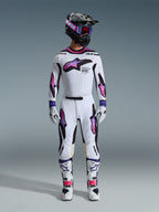 Motocross rider wearing complete racing gear, Alpinestars 2026 Supertech AFD Vista Jersey in White Purple Black, matching white pants with purple and pink gradient graphics, white boots, and black helmet with purple goggles, professional off-road racing outfit