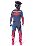 Alpinestars 2025 Techstar Dreem Gear Set, motocross rider wearing full racing gear, grayish-blue jersey and pants with vibrant pink, orange, and cyan blue accents, large 'astars' logo on chest, bright pink boots, black helmet with goggles, coordinated outfit for professional motocross