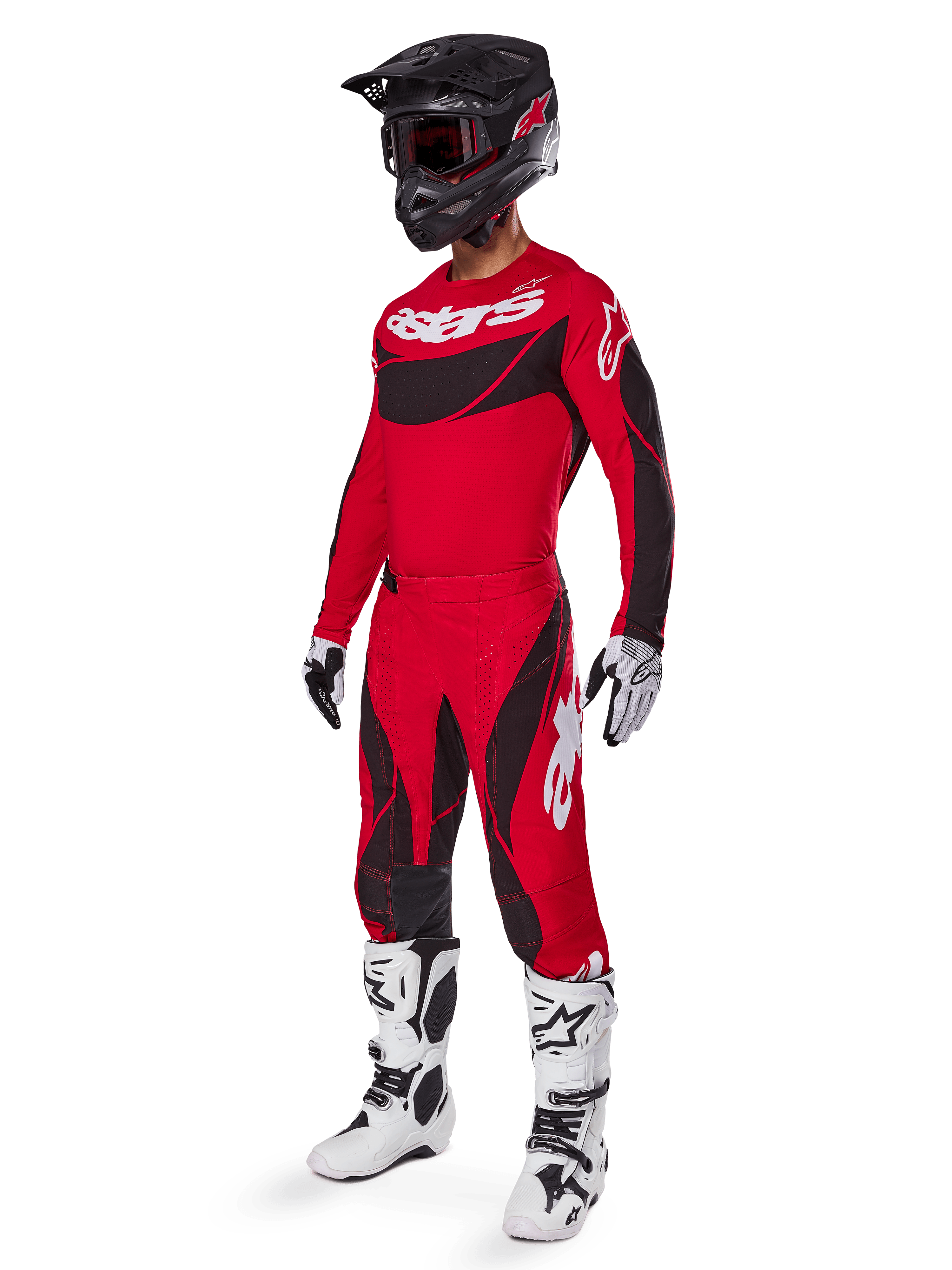 Full-body view of a motocross rider in the 2025 Techstar Dreem Gear Set in Bright Red and Black, featuring a performance jersey with white branding, matching stretch ripstop pants, a black helmet with a red visor, white and black gloves, and white Tech boots, specialized racing outfit for off-road competition.