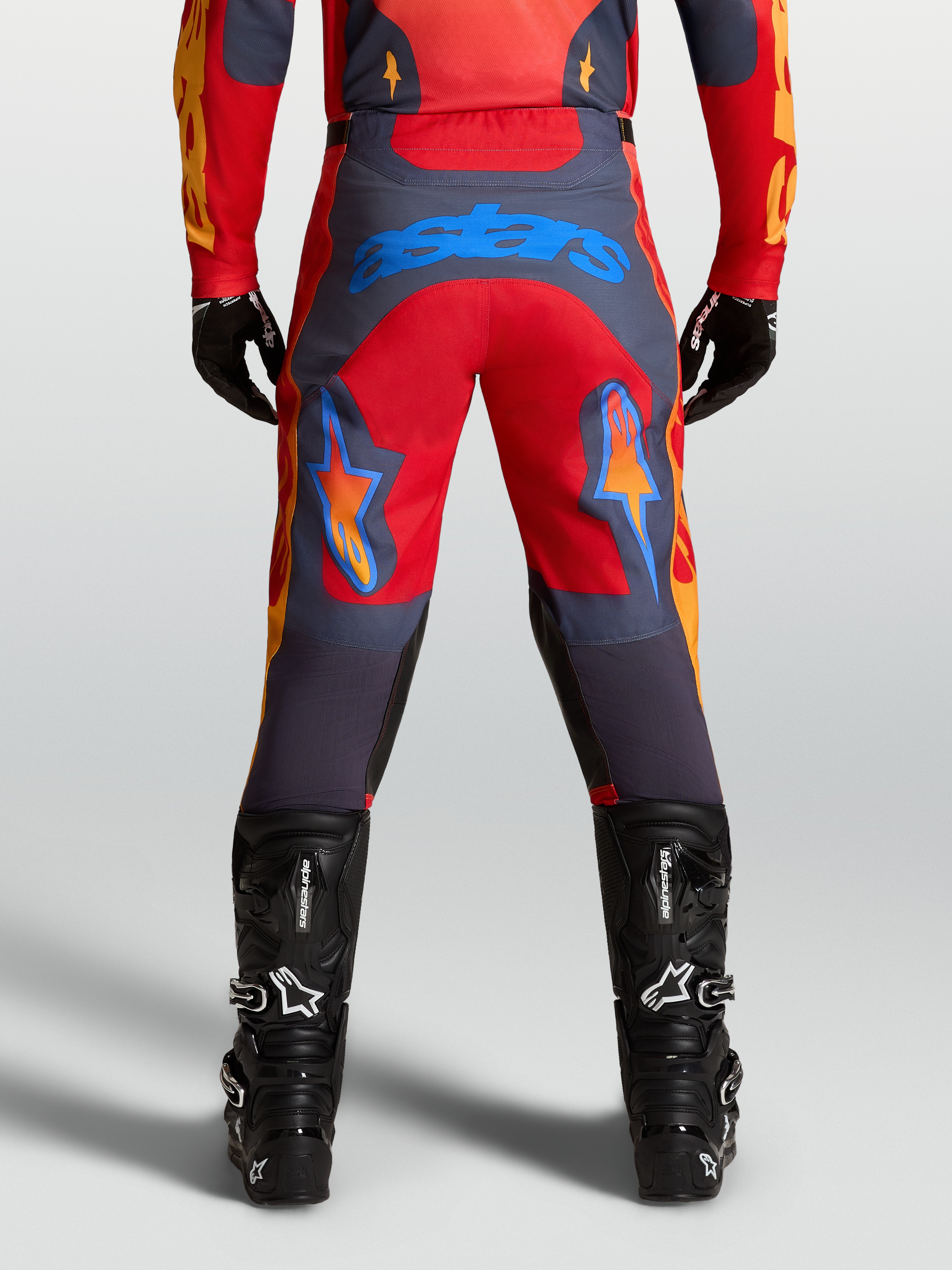 Alpinestars Racer Hunt Pants in Fire Red and Graystone, men’s motocross pants with pre-curved leg construction and blue Astars logo on seat.