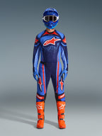Motocross rider wearing the Alpinestars 2026 Techstar Nomur Jersey in Dark Navy, Orange, and UCLA Blue, paired with matching motocross pants, a blue helmet with goggles, and bright orange racing boots, full coordinated off-road competition gear