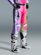 Alpinestars 2026 Racer Air Portl Pants, Motocross Pants, Multicolor graphic with purple, pink, and orange gradients, worn with white and black motocross boots and black gloves, featuring a race fit design and tan leather inner knee panels.
