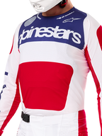 Alpinestars Limited Edition Techstar Fortitude Gear Set, Motocross Jersey and Pants in Red White and Blue, featuring a white jersey with a navy blue upper panel and a large red center graphic, matching white and red pants with an SX2 magnetic buckle, athletic fit with laser-cut perforations for off-road racing.