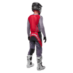 Alpinestars 2024 Supertech Dade Jersey, Motocross Jersey, Iron Red Berry and Grey, back view on a rider, featuring a red back panel with a grey logo and grey sleeves, worn with coordinating grey and red racing pants, white boots, and a black helmet, professional off-road gear.