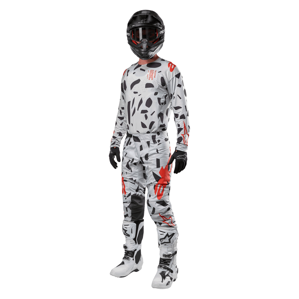 Motocross rider wearing Alpinestars 2024 Techstar Rantera Jersey in Haze Gray Camo, matching pants with red and black accents, black helmet and goggles, black gloves, white and black boots, complete coordinated motocross racing gear for off-road performance