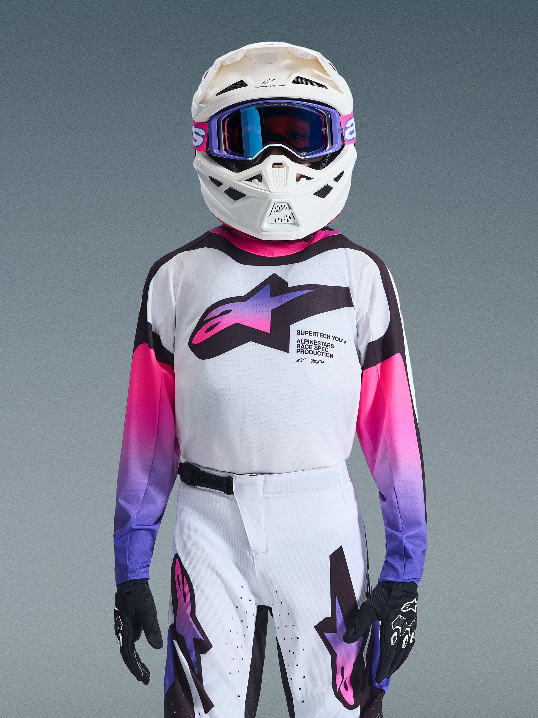 Alpinestars 2026 Youth Supertech Vista Jersey, Motocross Jersey, White with Pink and Purple gradient logos, worn with matching white pants and white helmet with purple goggles, pro-level athletic fit for off-road racing