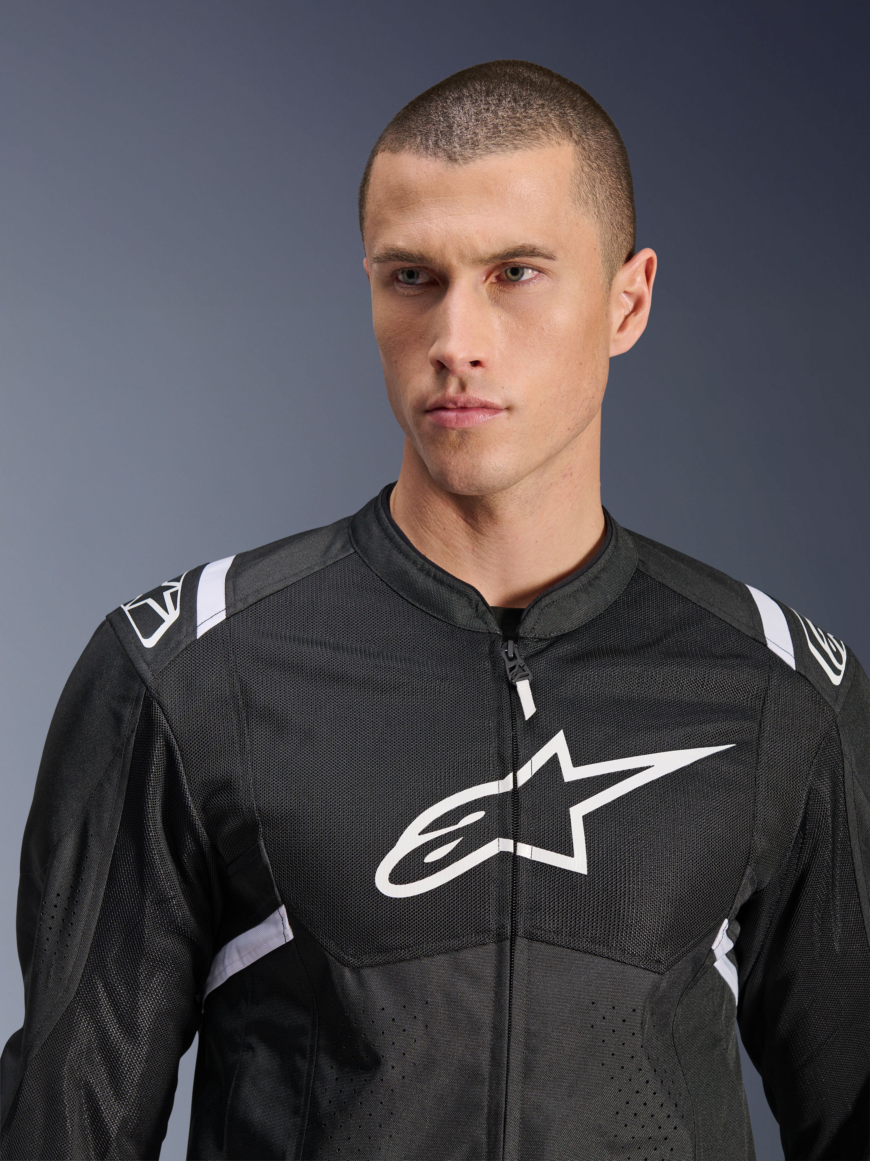 Alpinestars T-SPS Air V2 Jacket, Textile Motorcycle Jacket, Black and White, featuring large white chest logo and mesh paneling, performance sport fit worn by male model