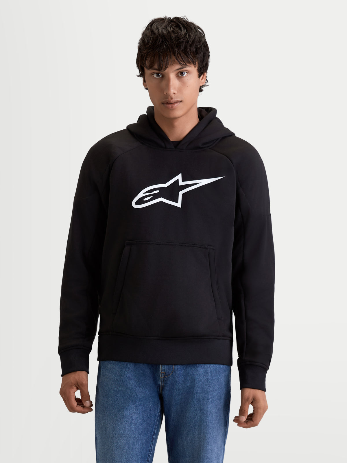 Alpinestars Ageless Hoodie, men's urban motorcycle hoodie in black with a white logo on the chest, front pouch pocket, and casual textile construction, front view on a model