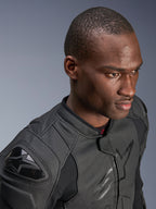 Close-up of a model wearing the Alpinestars Dusk Airflow Leather Jacket, Black on Black, featuring extensive perforated leather for breathability, external DFS shoulder sliders, and a sleek modern design for sport riding.