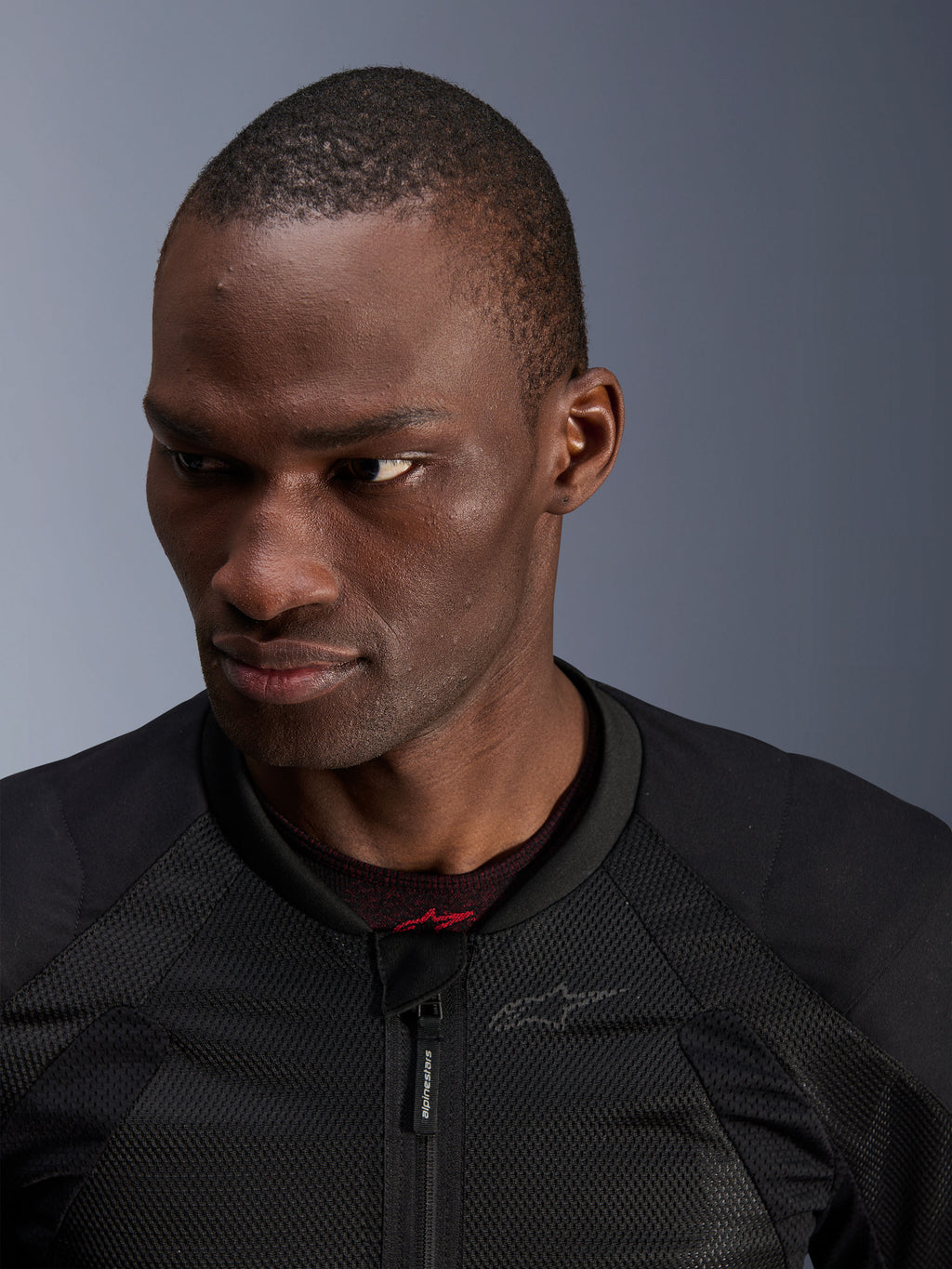 Alpinestars Troop-Air Jacket, Black Motorcycle Jacket, close-up view of a rider featuring advanced mesh construction, front zipper with Alpinestars branding, and subtle logo detail.