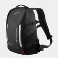 Alpinestars AMP3 Backpack, Black technical motorcycle bag with white logos, silver reflective panels, red zipper pulls, adjustable side compression straps, and padded mesh shoulder straps.