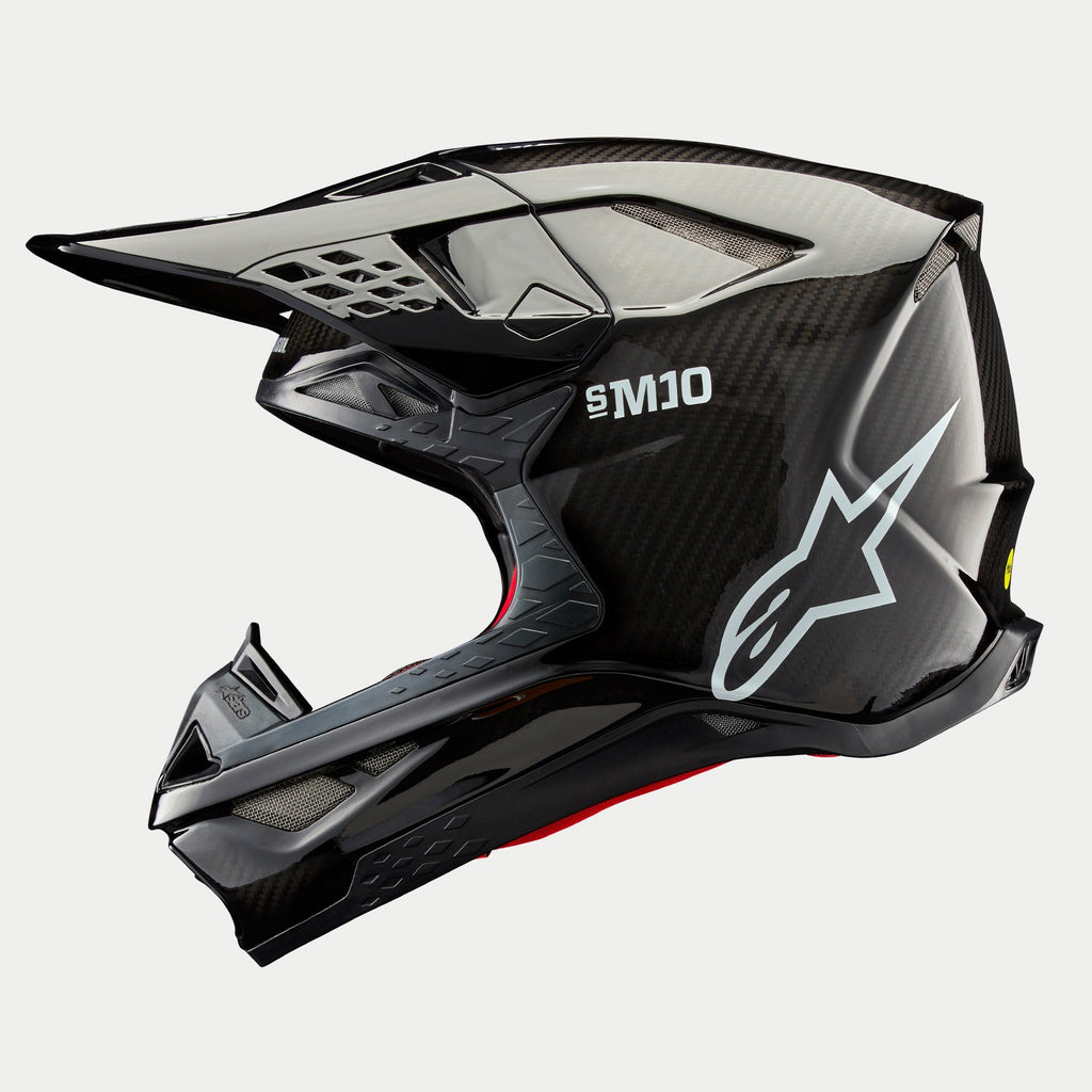 Alpinestars Supertech M10 Solid Helmet, Motocross Helmet, Black Glossy Carbon, side profile featuring exposed carbon fiber weave, white SM10 branding and Alpinestars logo, streamlined aerodynamic design with mesh-covered ventilation ports