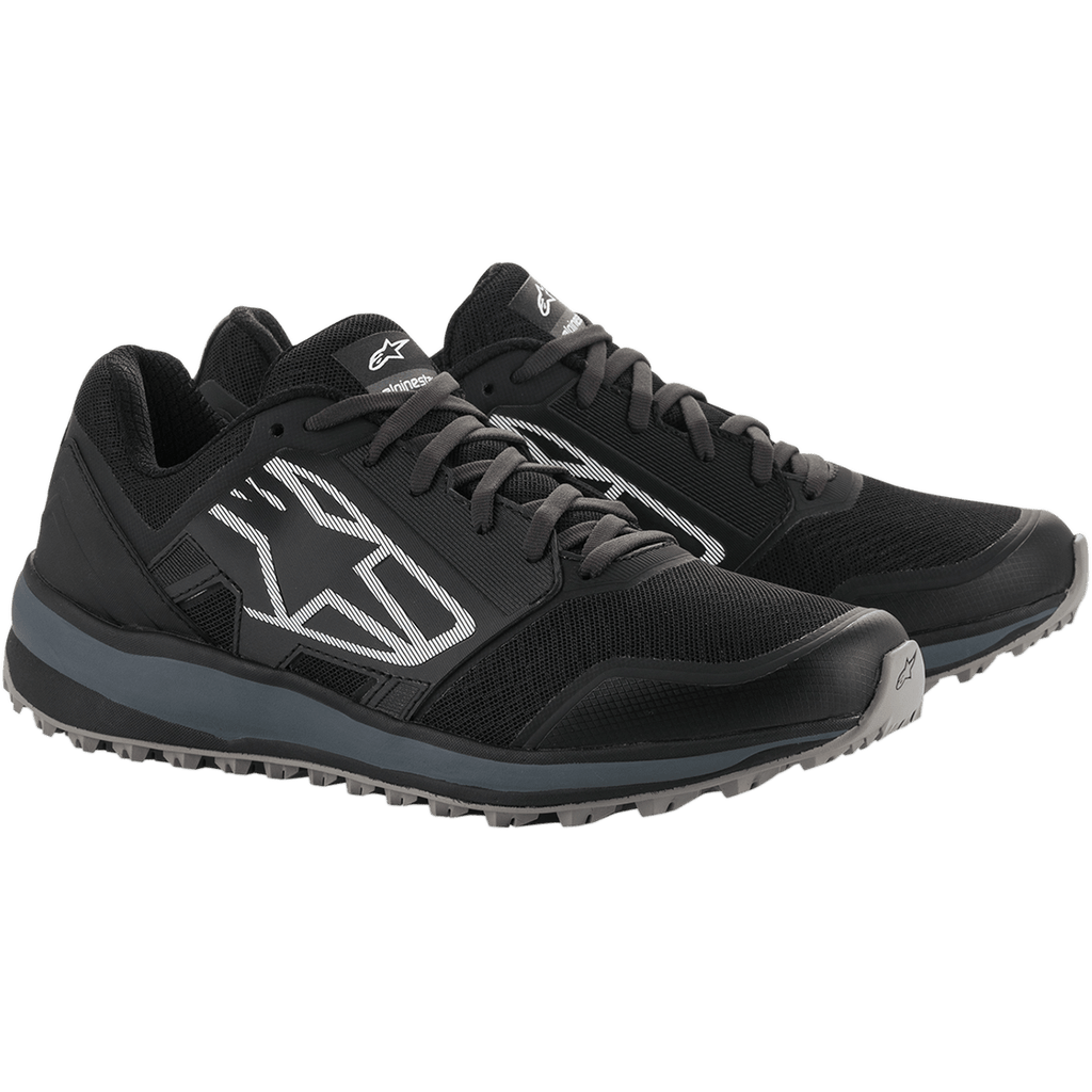 Alpinestars Meta Trail Shoes, performance running shoes, Black and Dark Gray, large white striped Astars logo on the side, lace-up design with a rugged gray sole, designed for all-day comfort in the paddock