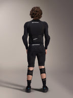 Alpinestars A-Impact Plasma Protection Jacket - Long Sleeve, back view, black with white Alpinestars logos, worn with protective shorts and knee guards for full-body mountain bike protection