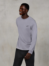 Alpinestars Essentials Ageless LS Tee, Long Sleeve T-Shirt, Silver, small black logo on the chest, worn by a smiling model with dark pants, relaxed contemporary fit, casual motorsport lifestyle apparel