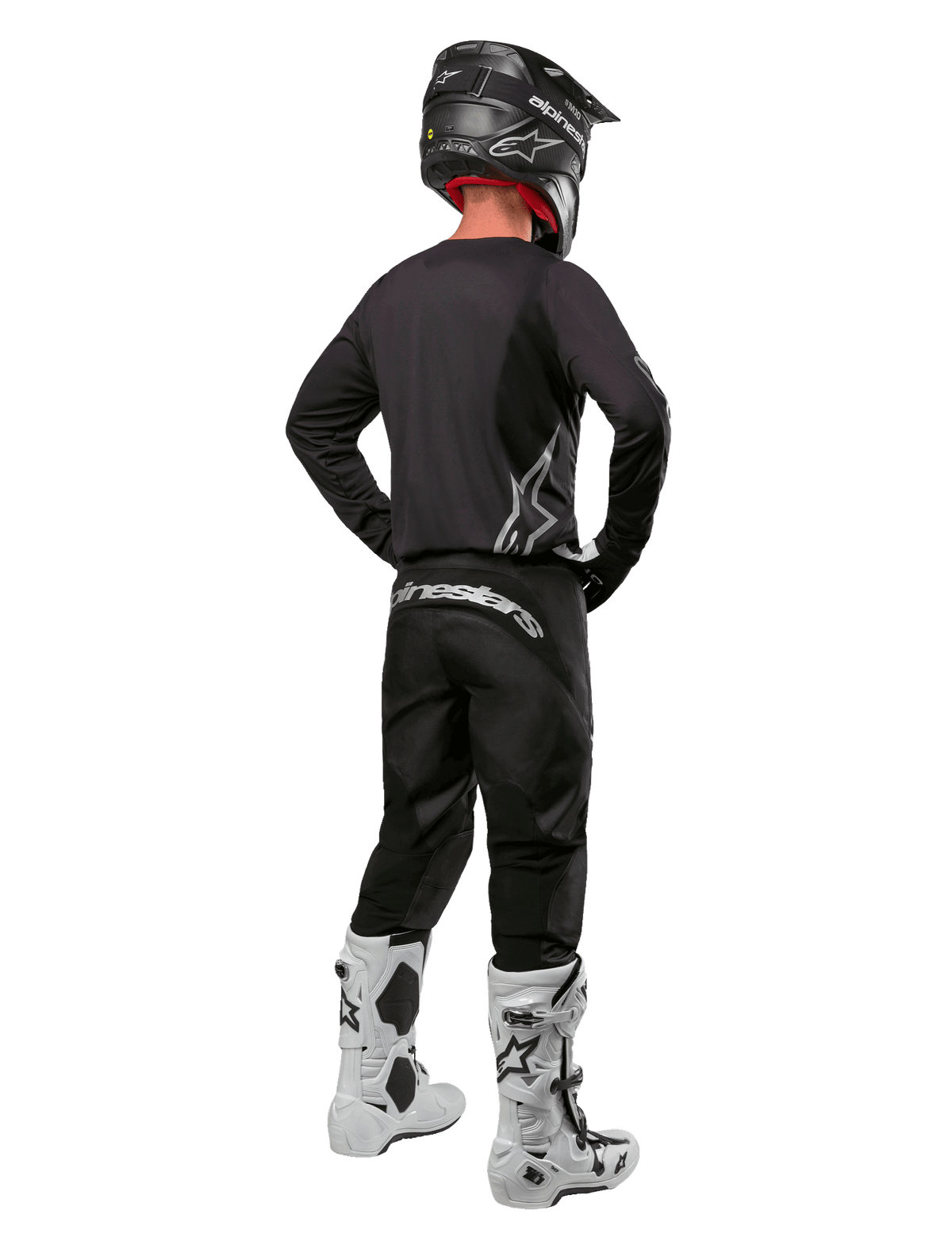 Alpinestars 2024 Fluid Graphite Gear Set, Motocross rider viewed from the back, graphite gray jersey and pants with silver Alpinestars branding, black helmet and white motocross boots, athletic fit gear for off-road riding